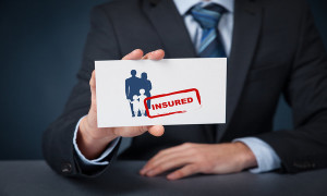 Insured family concept. Insurance agent with family silhouette on card and printed stamp insured.