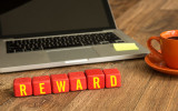 Reward written on a wooden cube in office desk