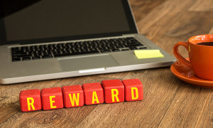 Reward written on a wooden cube in office desk