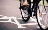 City bicycle riding on bike path alternative ecological transportation. Commute on bicycle in urban environment asphalt gray bike lane with bicycle markings