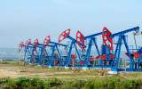 Oil and gas industry. Work of oil pump jack on a oil field. White clouds and blue sky. oil well pump. Oil and gas industry. Work of oil pump jack on a oil field.
