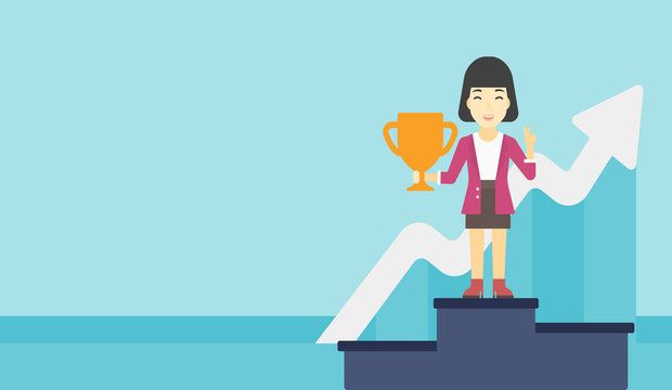 An asian business woman standing on a pedestal with winner cup.