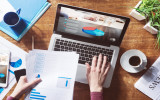 Financial report with pie chart and data on a laptop with business woman's hands at work