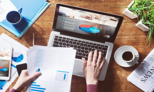 Financial report with pie chart and data on a laptop with business woman's hands at work