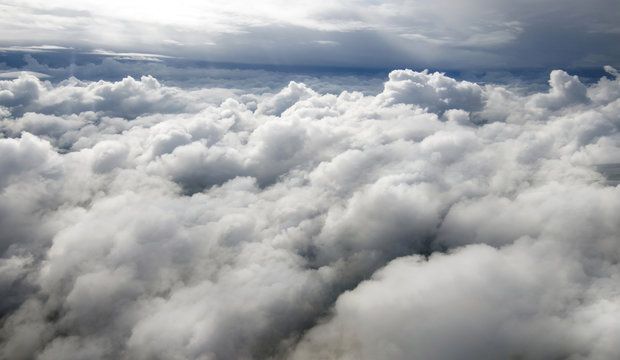 Above the clouds in the sky.