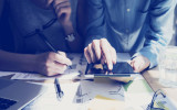 Photo Woman Hand Touching Digital Tablet Screen.Analyst Department Researching Process.Young Business Crew Working New Startup modern Studio.Analyze markets stocks.Blurred, film effect.Wide