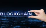 hand pushing blockchain button on blurred blue background