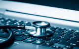 Computer or data analysis - Stethoscope over a laptop computer keyboard toned in blue
