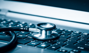 Computer or data analysis - Stethoscope over a laptop computer keyboard toned in blue