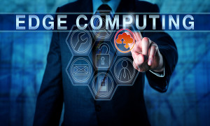 Business person is touching EDGE COMPUTING on an interactive virtual control display. Information technology metaphor and business concept for resource intensive distributed computing services.