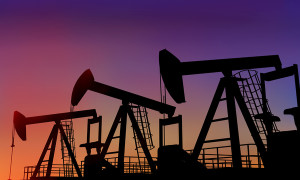 Illustration of three oil wells in the desert at dusk