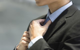 Close up detail of businessman adjusting his tie.