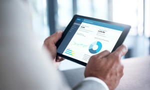 Cropped shot of a businessman using a digital tablet with graphs on the screen