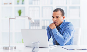 African American businessman sitting in his office and using computer.