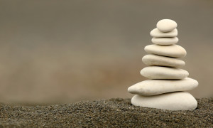 Balancing silky white stones in black grain sand