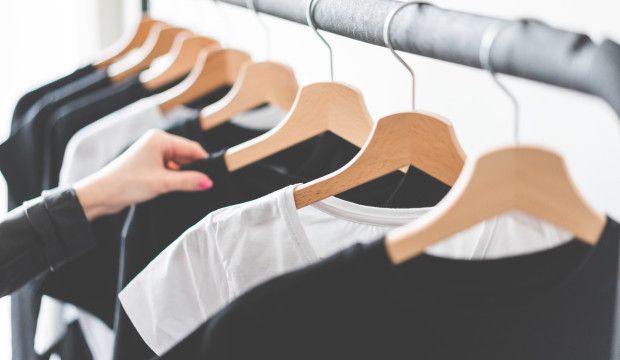 Cropped Hands Of Woman Holding Top Hanging In Store