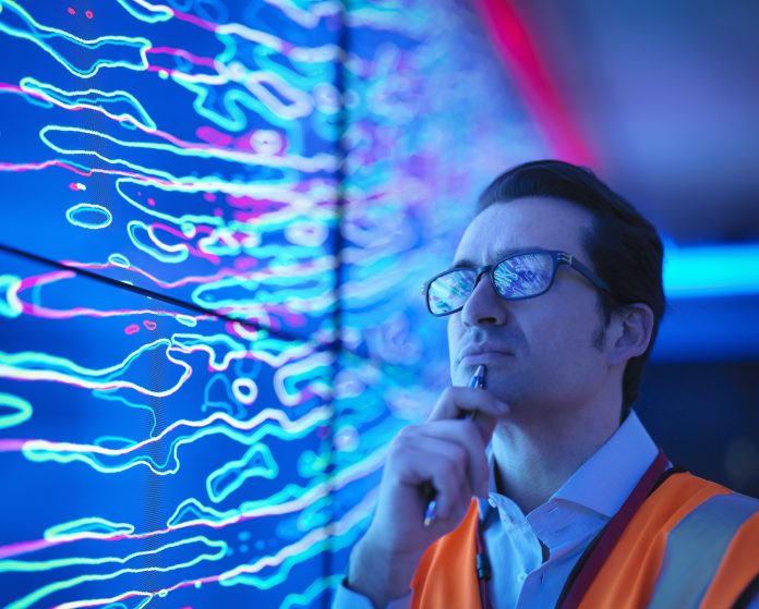 Geologist studying graphical display of oil and gas bearing rock on screens, close up