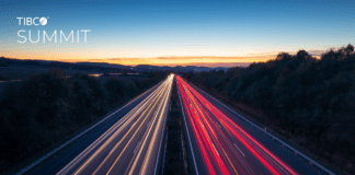 A long exposure image of a highway at dusk, with white headlights on the left and red taillights on the right, under a clear sky with the TIBCO Summit logo in the top left corner.