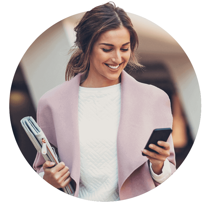 A smiling woman looking at her smartphone