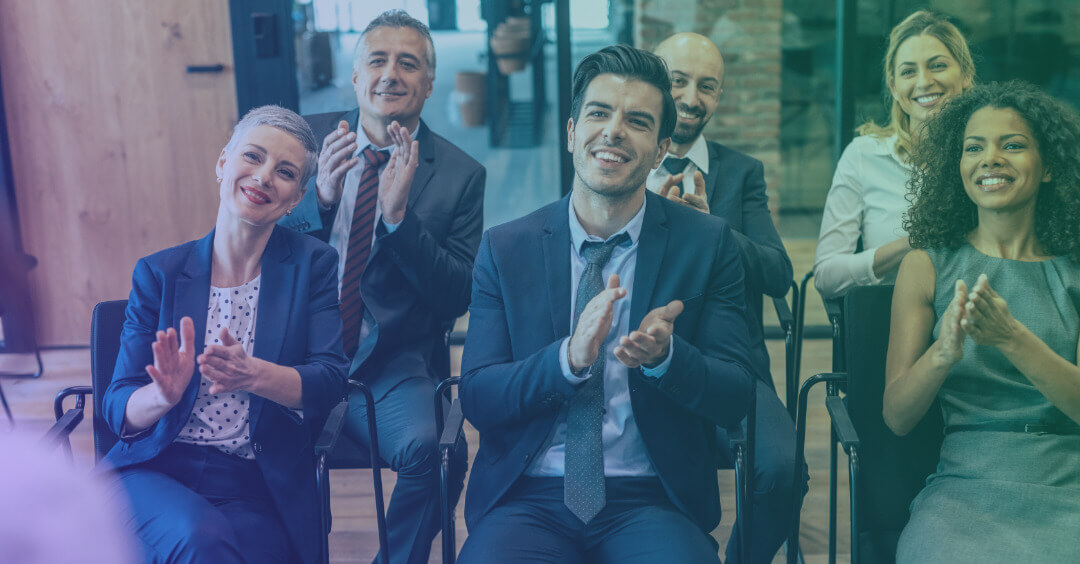 Audience clapping during a presentation in an office setting