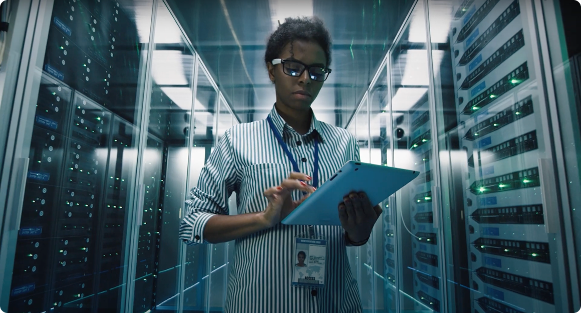 Person using a tablet in a server room