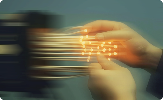 Hands connecting glowing fiber optic cables.