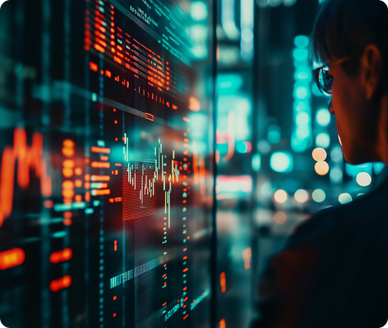 Person looking at a digital screen displaying charts and data in red and blue tones.