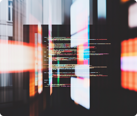 Colorful lines of computer code displayed on a screen with bright light reflections.